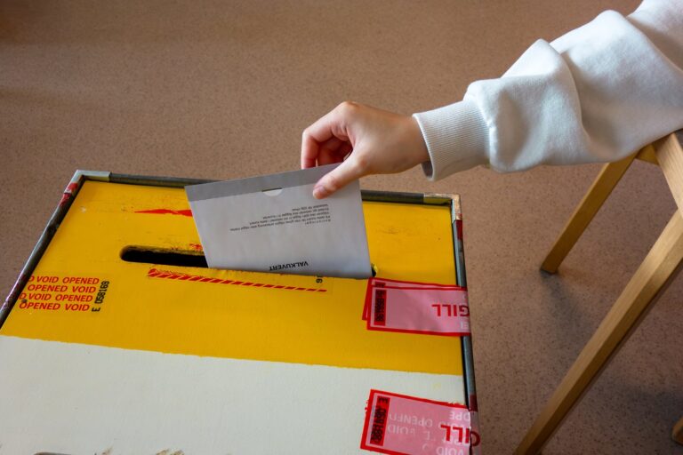Un électeur glisse une enveloppe de vote dans l'urne d'un bureau de vote